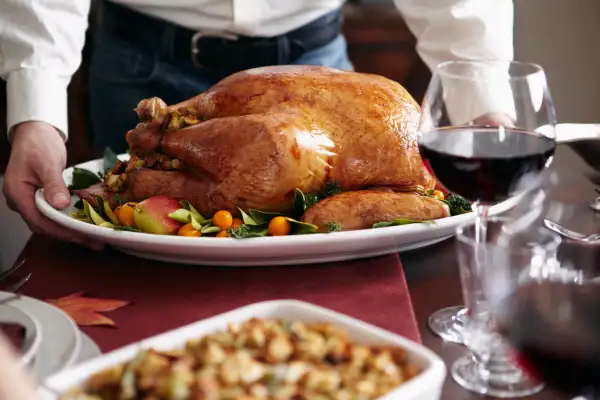 Man serving turkey dish at table