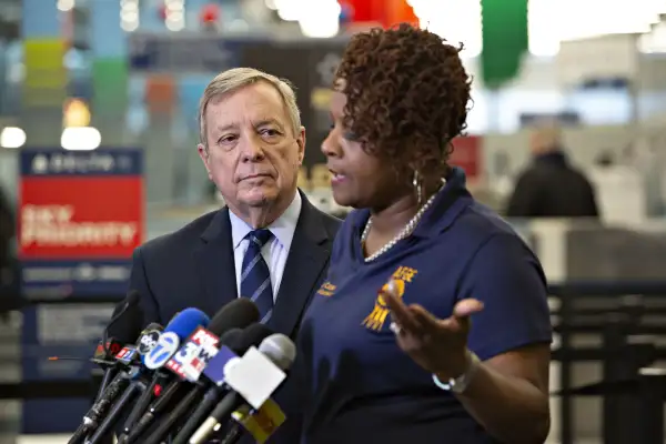 Janis Casey, women's coordinator for American Federation of Government Employees (AFGE), speaks while Senate Minority Whip Dick Durbin, a Democrat from Illinois, left, listens during a press conference on how the partial government shutdown is affecting Transportation Security Administration (TSA) employees at O'Hare International Airport (ORD) in Chicago, Illinois, U.S., on Tuesday, Jan. 8, 2019. With screeners already calling in sick in larger-than-normal numbers, U.S. airports are girding for disruptions next week if the partial government shutdown continues and TSA officers miss their first paycheck.