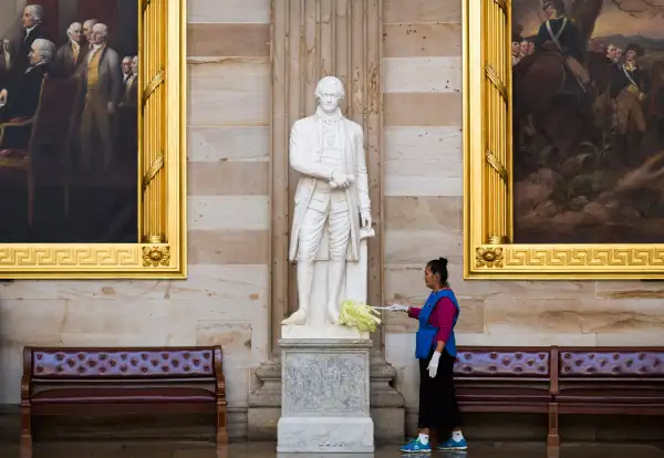 Maria Bernal de Navarrette cleans a statue of Alexander Hamilton, a Founding Father of the United States, in Rotunda on Capitol Hill in Washington October 15, 2013.