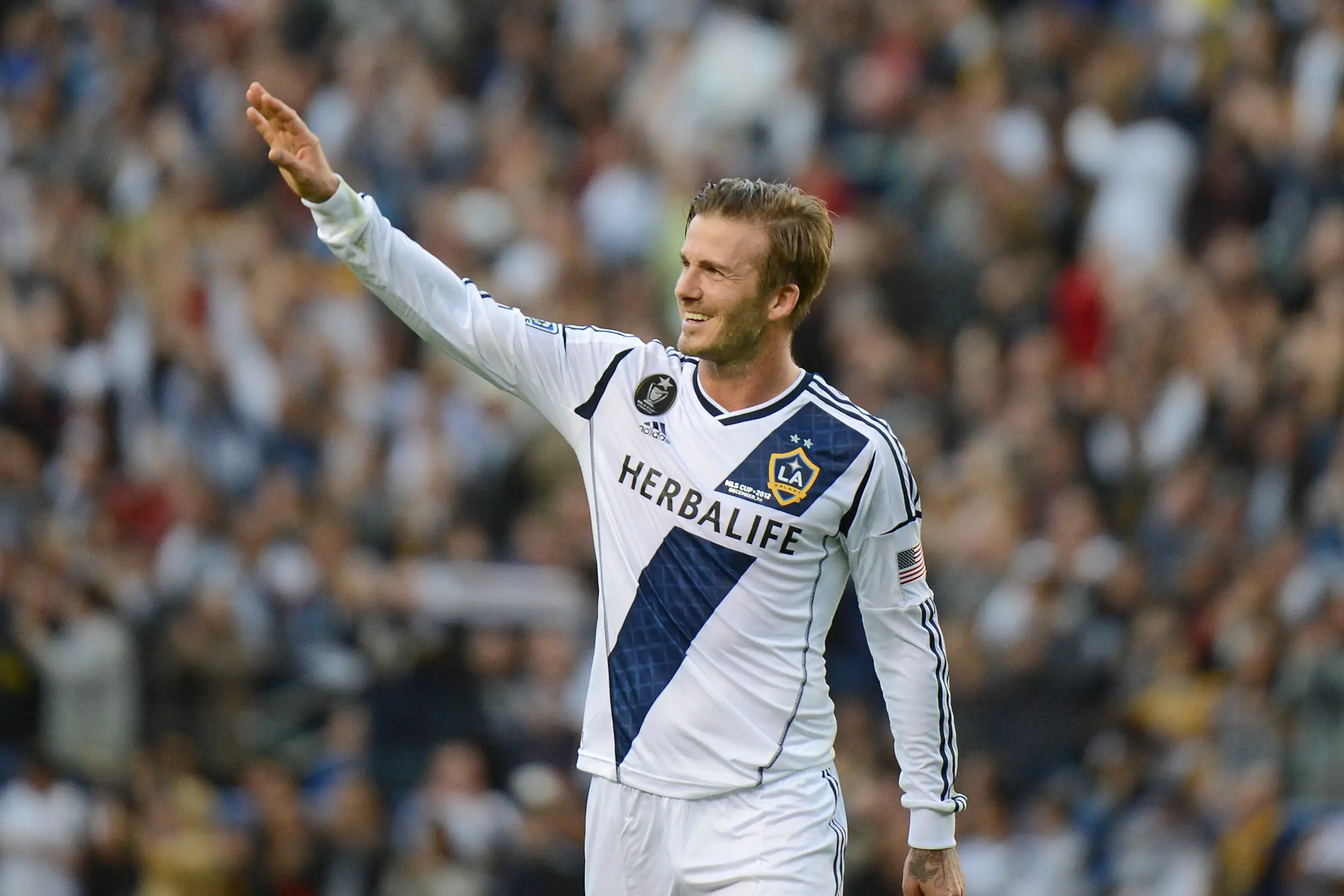 David Beckham waves to fans as he walks off the pitch after the Los Angeles Galaxy defeat the Huston Dynamo in the Major League Soccer (MLS) Cup, December 1, 2012 in Carson, California. It was Beckham's last game with the Galaxy.