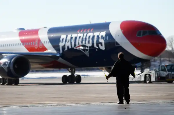 A member of the ground crew guides the team plane of the New England Patriots as it arrives for Super Bowl LII on January 29, 2018 at the Minneapolis-St. Paul International Airport in Minneapolis, MN.