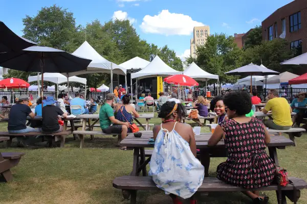 Crowd sitting at picnic benches at a park in Durham, North Carolina