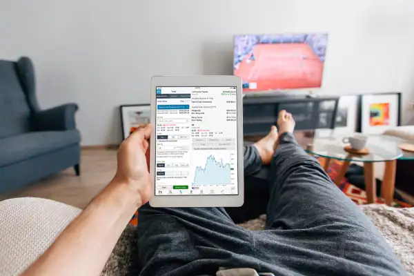 Man relaxing on the sofa in apartment and using digital tablet, personal perspective