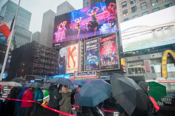 Visitors in the rain at the discount TKTS ticket booth in Times Square in New York.