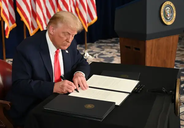 US President Donald Trump signs executive orders extending coronavirus economic relief, during a news conference in Bedminster, New Jersey, on August 8, 2020.