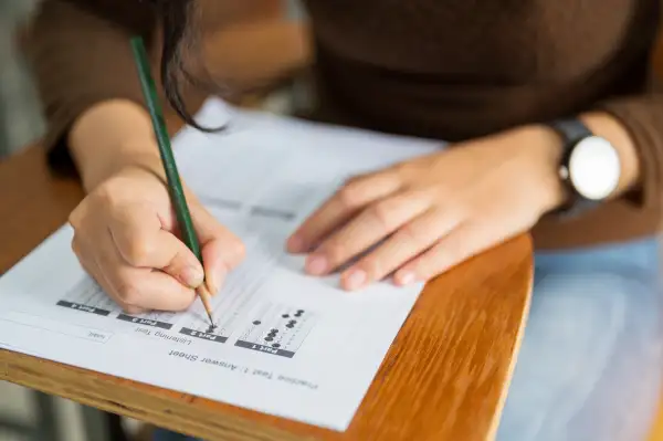 Woman sitting at a desk filling out a test answer sheet