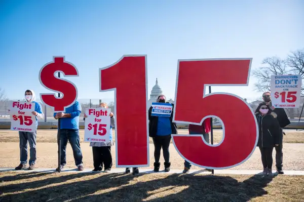 Activists with $15 minimum wage signs outside the Capitol