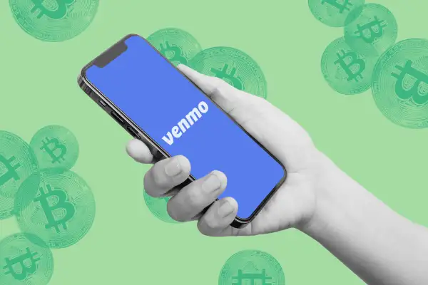 Venmo logo displaying on a phone screen with bitcoins in the background