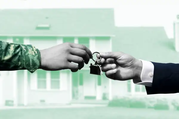 A person handing a military man house keys and a home in the background.