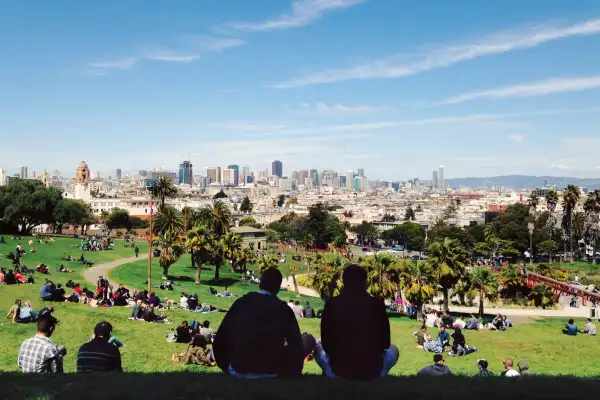 People sitting in a Park with the San Francisco Cityscape in the background