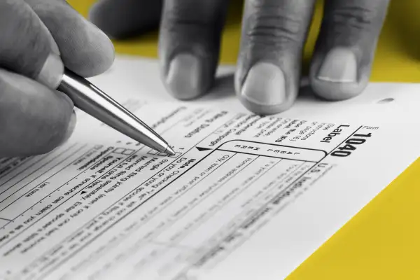 Close up of hands filling out a 1040 Tax Form