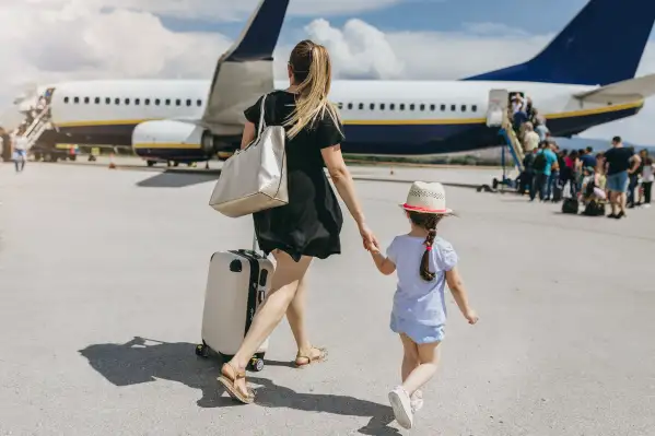 Young mother and her daughter boarding a plane