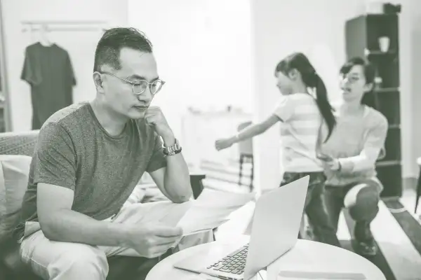 Man reading a letter with his wife and daughter in the background