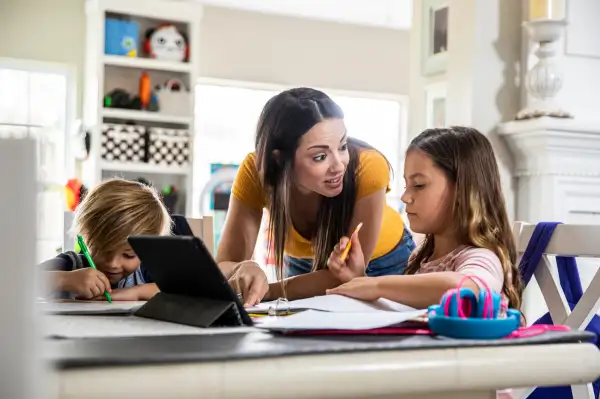 Mother working from home and homeschooling children