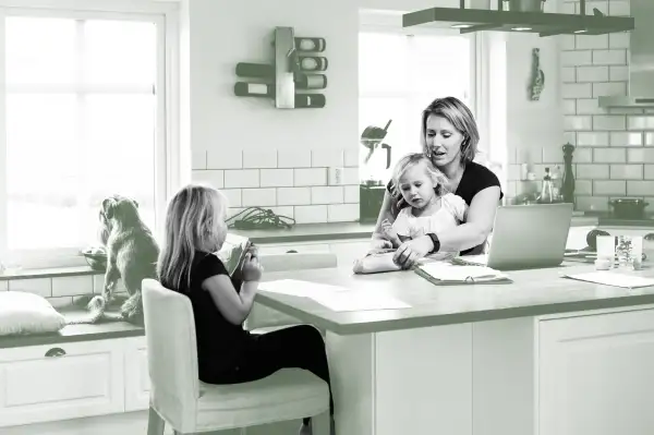 Mother with two daughters sitting at the kitchen counter.