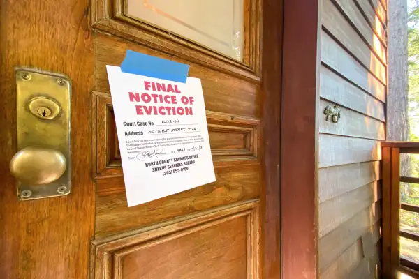 A door with a  Final Notice of Eviction  sign taped to it
