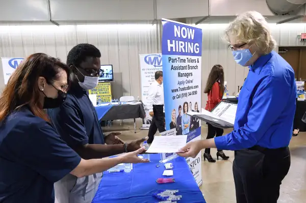 A man hands his resume to an employer at a Job Fair