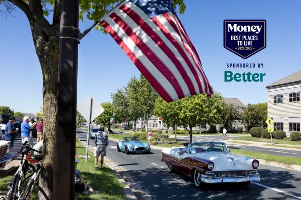 Old cars drive down a street in a car parade in Chanhassen, Minnesota