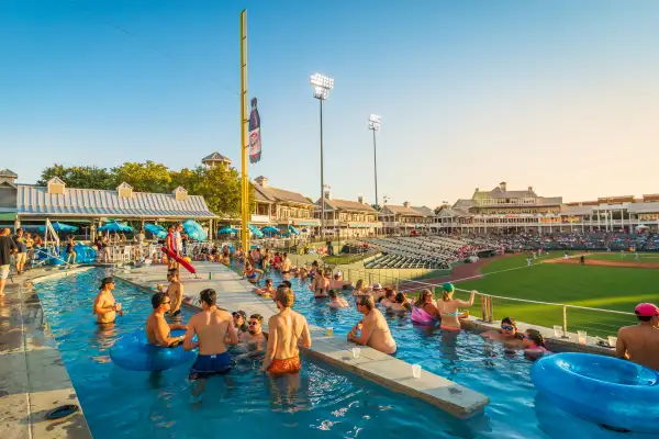 A group of people watch a baseball game from inside a pool in Frisco Texas