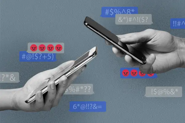 Two hands holding smartphones with text bubbles in the background with angry emojis and indecipherable text messages