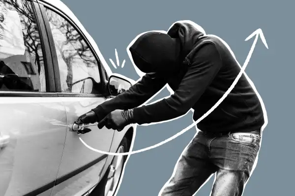Closeup of a man breaking into a car with a screwdriver
