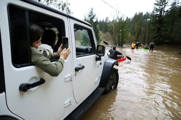 Residents attempt to navigate a flooded section of highway 116 on February 27, 2019 in Guerneville, California