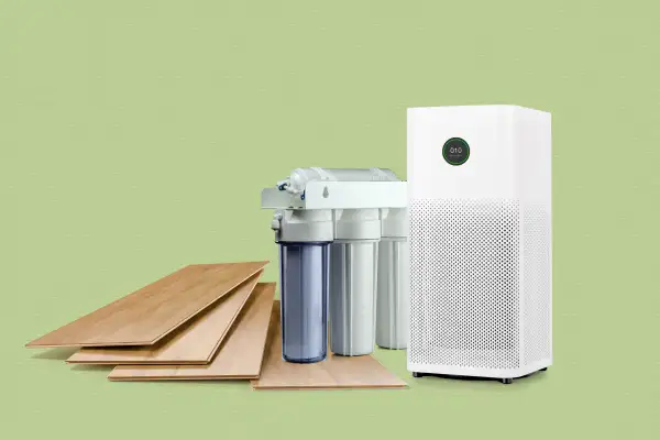 Wooden floor panels next to a water filter and air purifier on a colored background