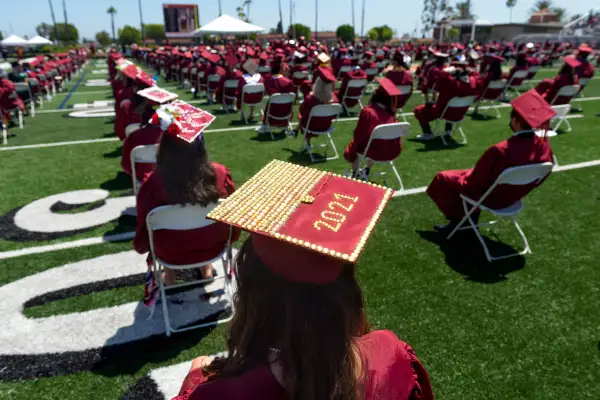A graduate wears a decorated 2021 cap during commencement for El Modena High School
