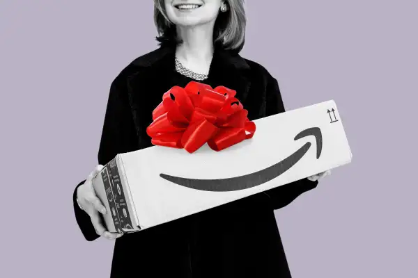 Closeup of a woman holding an Amazon delivery box with a big red gift bow on top.