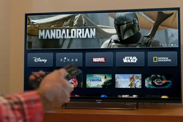 A person watching Disney+ on a Smart TV