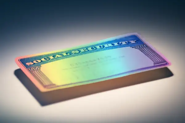 A rainbow colored social security card in the spotlight.