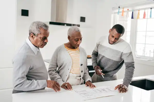 Senior couple looking over house blue prints with Real Estate Agent