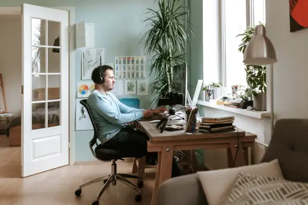 Man working on his computer from his home office.