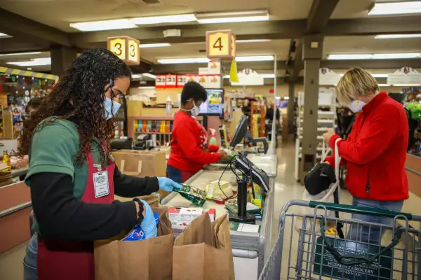 Retail workers in a California store bag items for a costumer