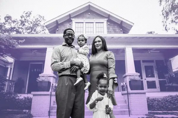 Portrait of a couple outside of their home with their two daughters