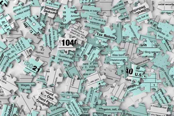 Messy jigsaw puzzle pieces of a 1040 Tax Form