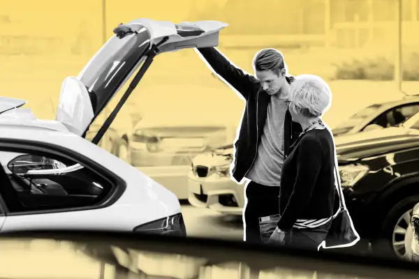 Mother and son examining a car in dealership