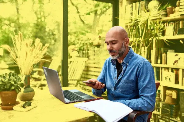 Mature man talking on his mobile phone, while working from home