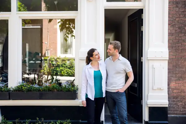 Lovely couple standing in front of their new house