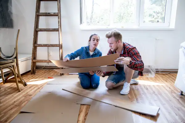 A couple looking at laminate wood flooring in their living room