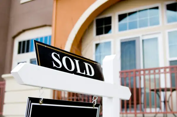 Close-up of a Sold sign in-front of a house