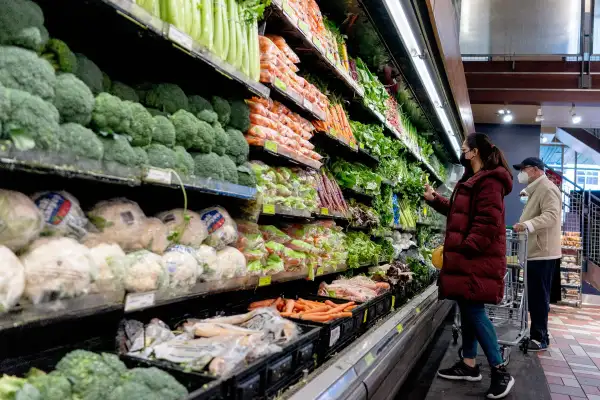 People at a grocery stores picking vegetables