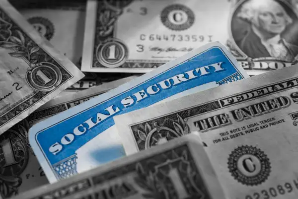 Photo of a social security card surrounded by money bills