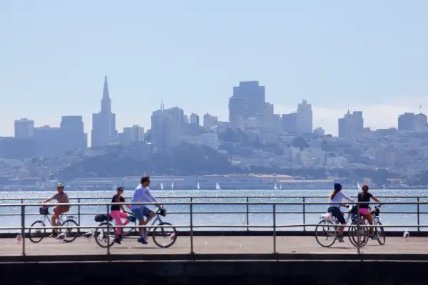Photo of a family biking alongside the San Francisco skyline