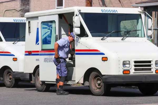 Post worker alongside USPS truck