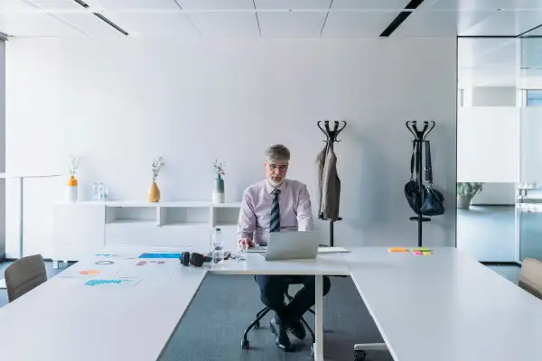 Senior man working alone in an office conference room