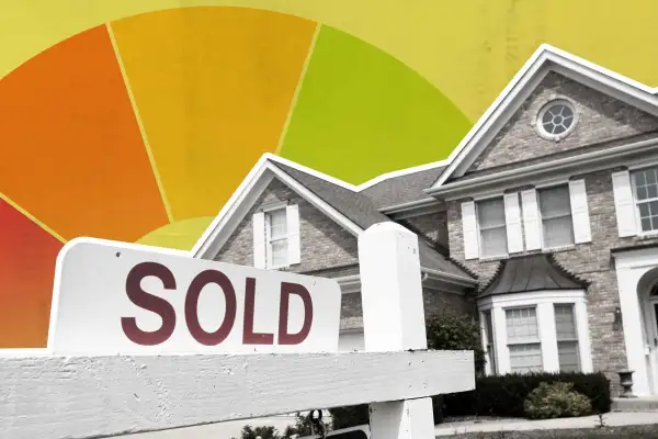 A Sold Sign In Front Of A House With A Large Credit Wheel Behind It