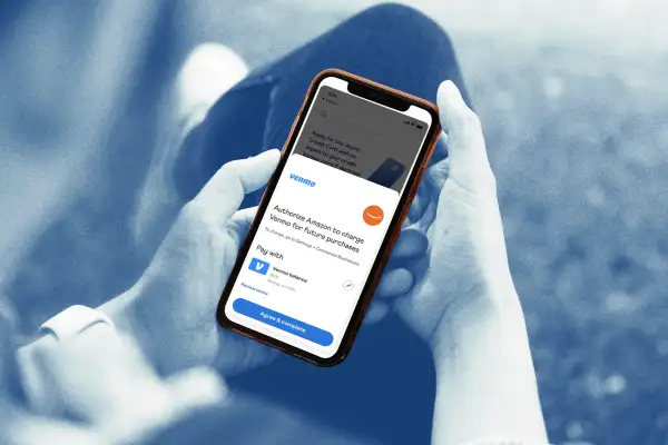 Close-up of a person using a smartphone authorizing Amazon through Venmo app