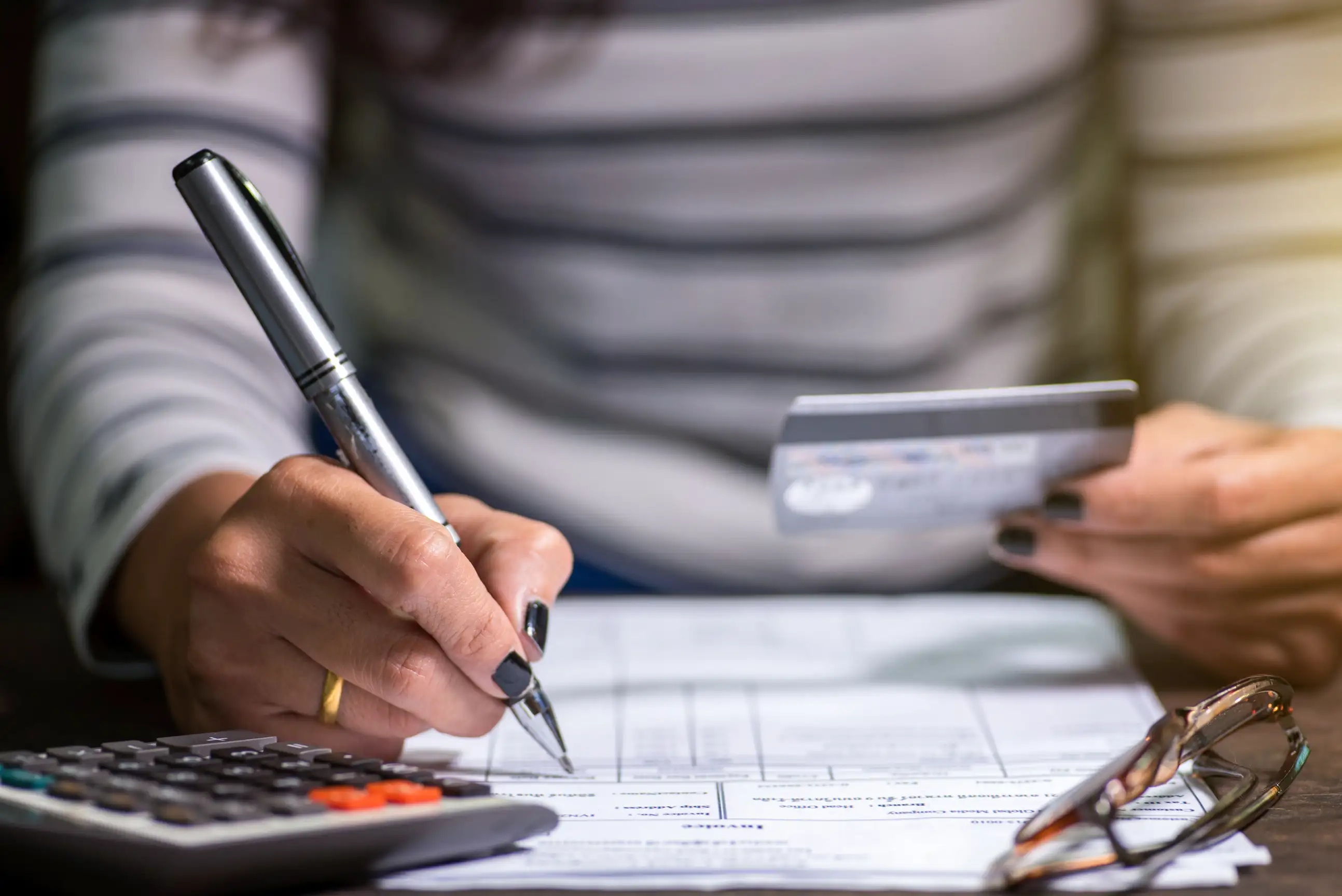 Closeup of a person holding a credit card and filling out a form