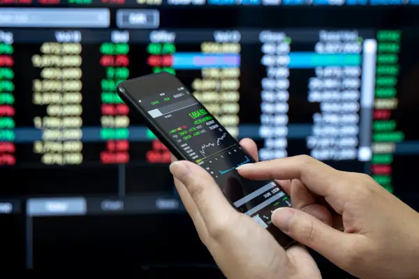 Businessman checking stock market on mobile phone